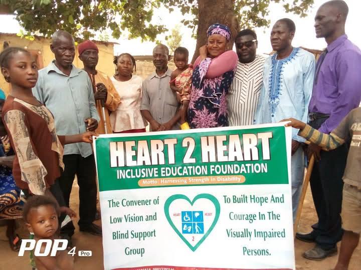 Community holding Heart 2 Heart Inclusive Education Foundation banner